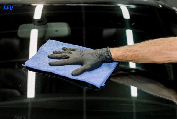 Technicien FFV en train de réparer un pare-brise dans un centre de vitrage à Paris