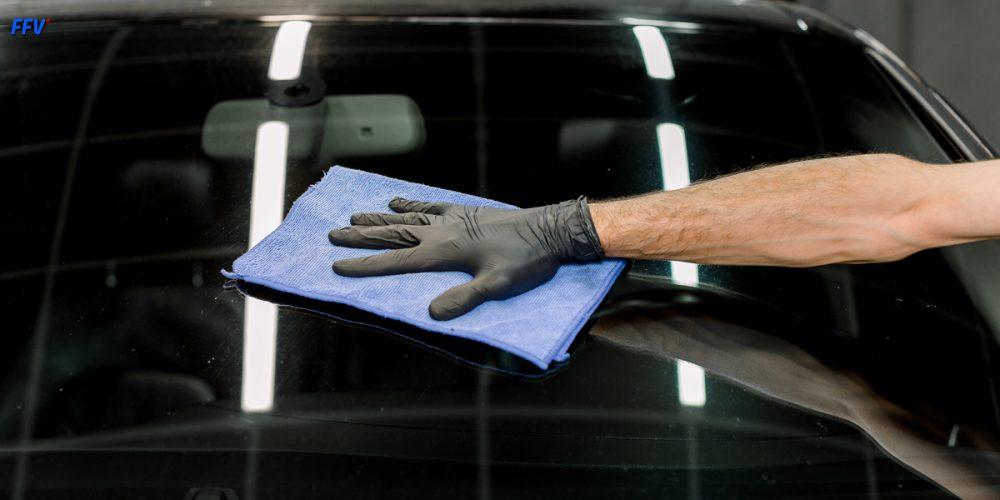 Technicien FFV en train de réparer un pare-brise dans un centre de vitrage à Paris